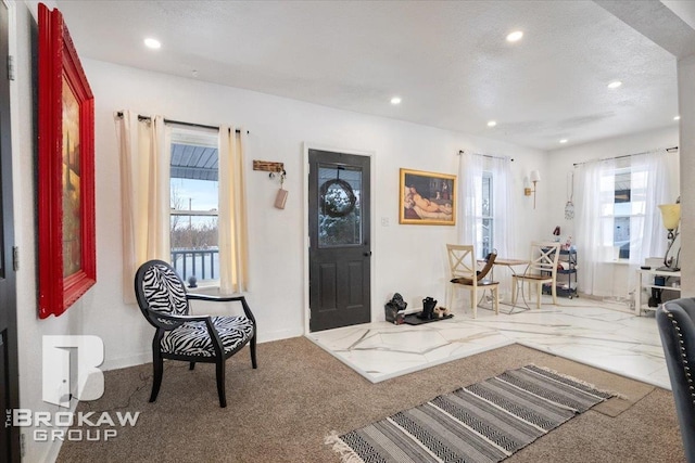 carpeted entrance foyer featuring a textured ceiling and recessed lighting