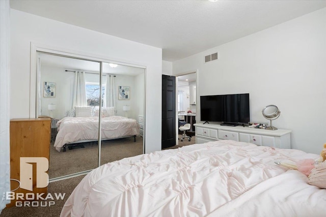 bedroom featuring a closet, visible vents, and dark carpet