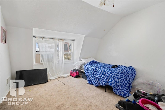 carpeted bedroom featuring vaulted ceiling and visible vents