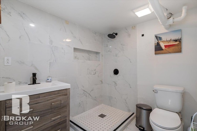 bathroom with vanity, a shower stall, and toilet