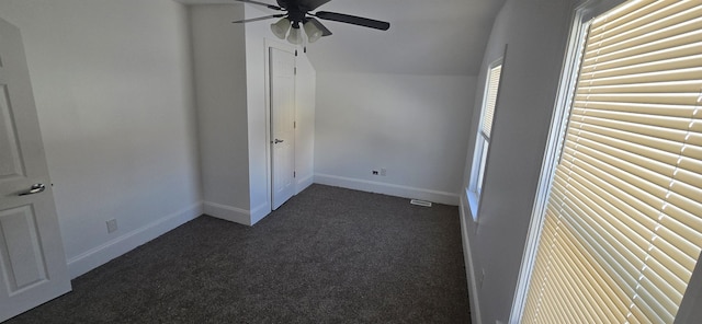 unfurnished bedroom featuring lofted ceiling and dark colored carpet