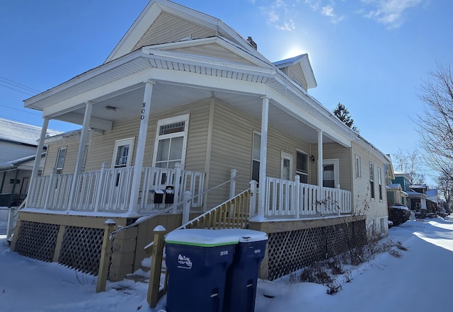 snow covered property featuring a porch