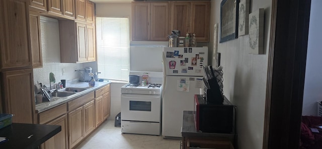 kitchen with sink, white appliances, and tasteful backsplash