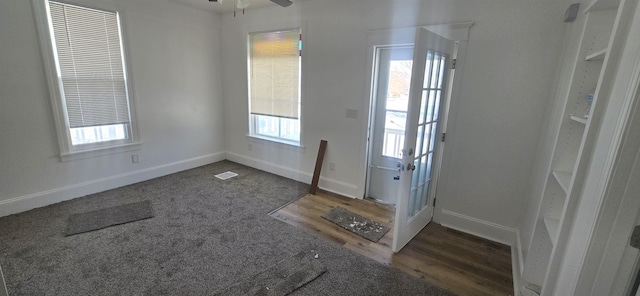 doorway with ceiling fan and dark wood-type flooring