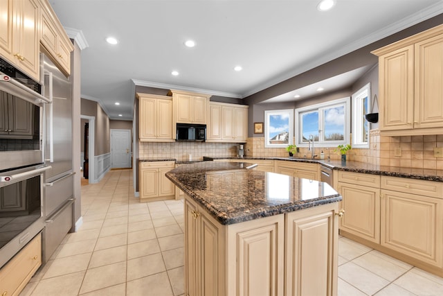 kitchen with dark stone countertops, sink, a kitchen island, and decorative backsplash