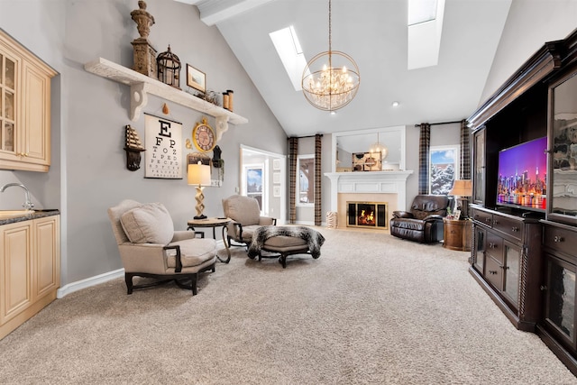 living area with sink, a skylight, beamed ceiling, and light colored carpet