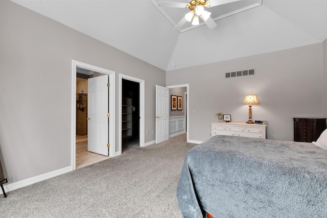 carpeted bedroom with ceiling fan, lofted ceiling, and a walk in closet