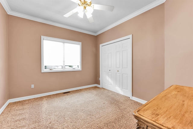 unfurnished bedroom featuring a closet, ceiling fan, carpet flooring, and ornamental molding