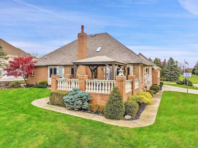 back of house featuring a lawn and a gazebo