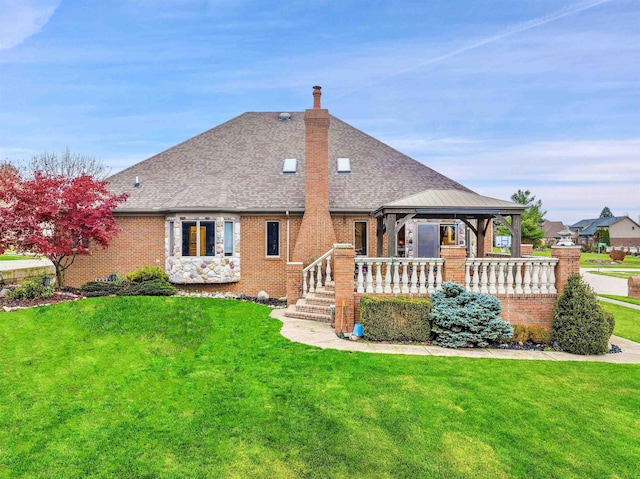 rear view of house featuring a yard and a gazebo