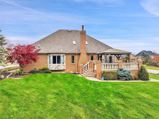 rear view of property with a lawn and a gazebo