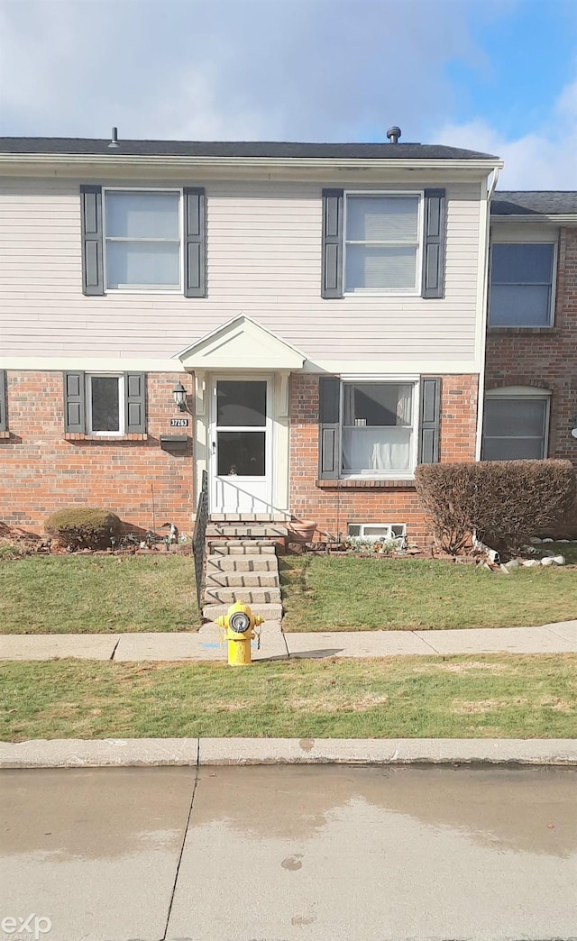 view of front of property with brick siding and a front yard