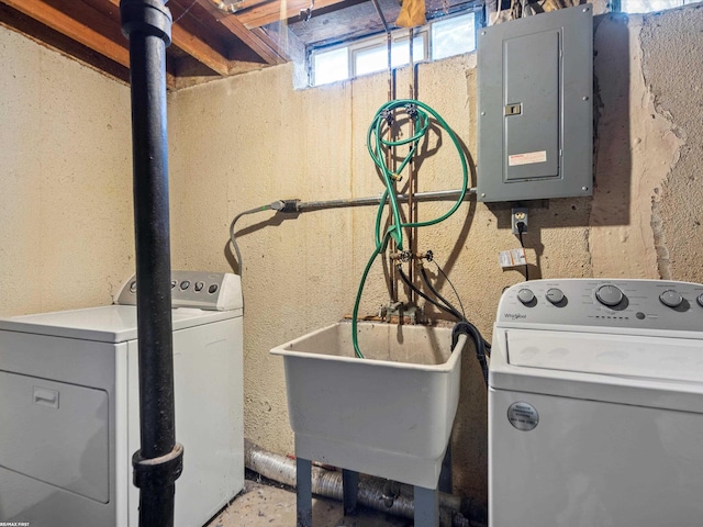 clothes washing area with washing machine and clothes dryer, electric panel, a sink, and laundry area