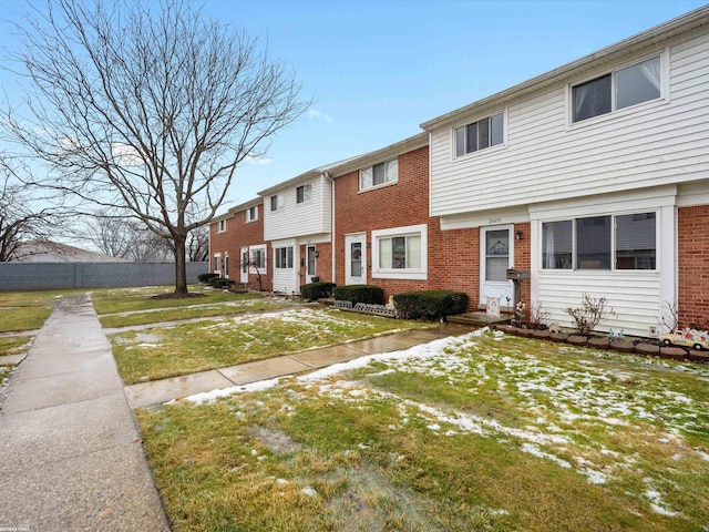 townhome / multi-family property featuring fence and brick siding