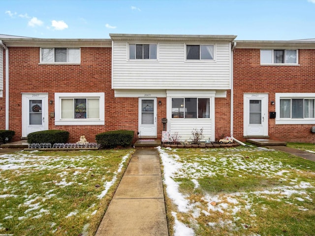 view of property with brick siding and a front yard