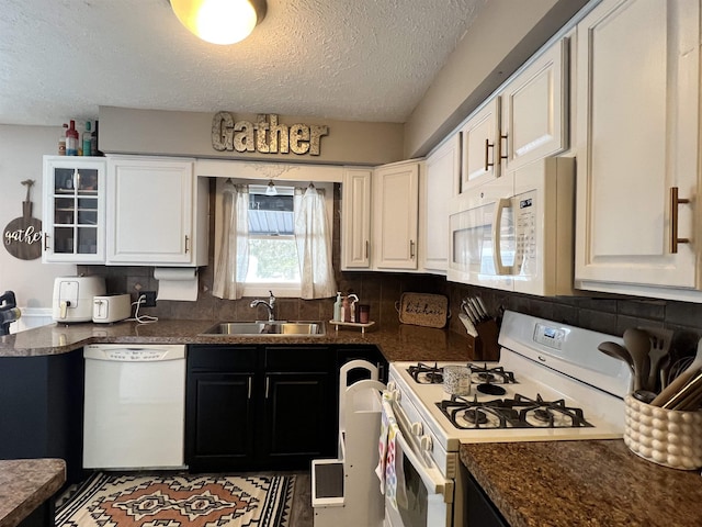 kitchen with a sink, white cabinets, a textured ceiling, and white appliances