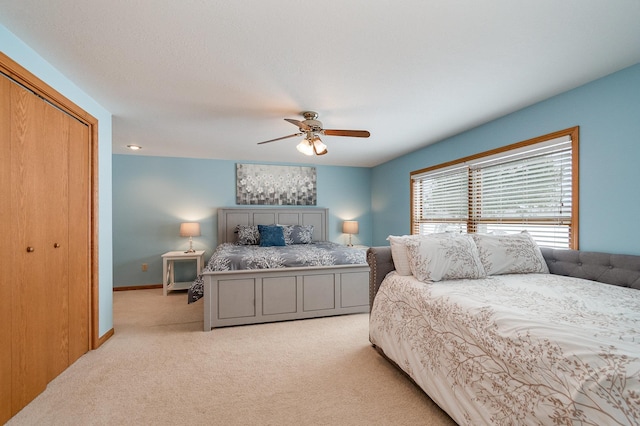 bedroom featuring baseboards, ceiling fan, and light carpet