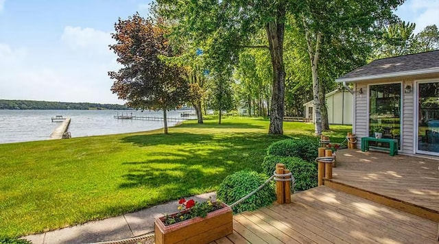 wooden terrace featuring a water view and a yard