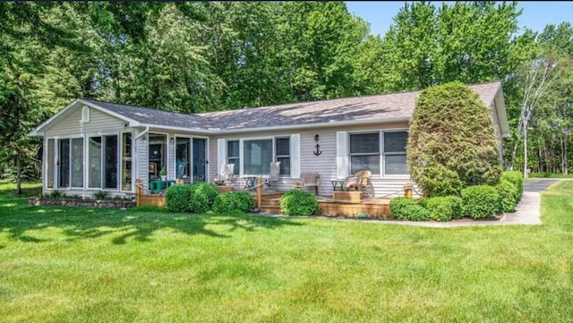 view of front of home featuring a front lawn and a sunroom