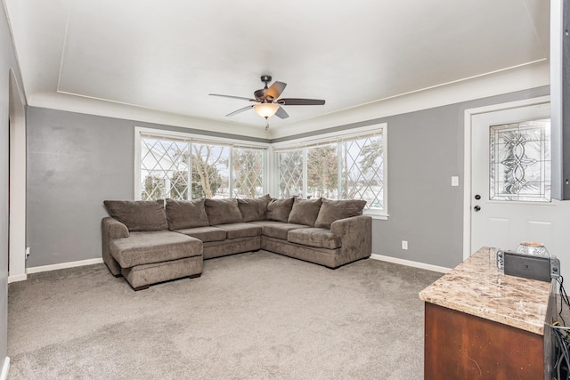 living area with carpet, baseboards, and a ceiling fan