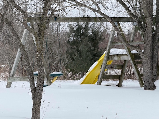 yard covered in snow featuring a playground