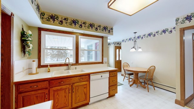 kitchen with pendant lighting, light floors, light countertops, a sink, and dishwasher