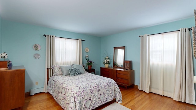 bedroom featuring light wood-style floors and baseboard heating