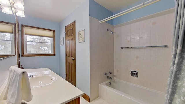 bathroom with shower / bath combination with curtain, vanity, and an inviting chandelier