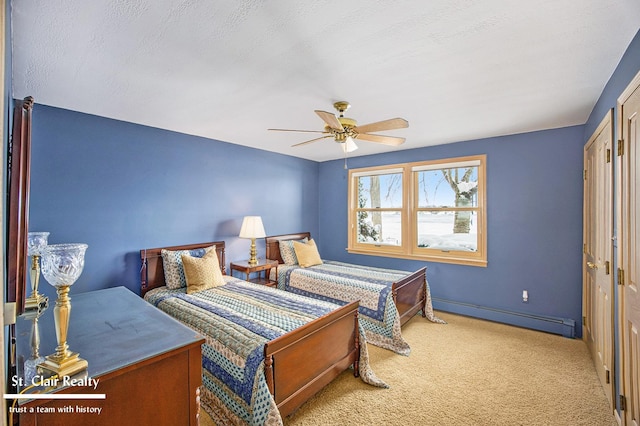 carpeted bedroom with baseboards, a baseboard heating unit, and ceiling fan