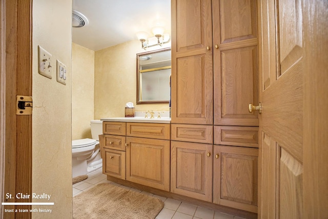 bathroom featuring visible vents, toilet, tile patterned floors, vanity, and a closet