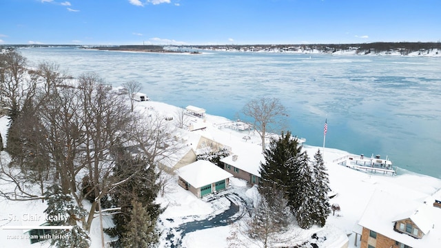 snowy aerial view featuring a water view