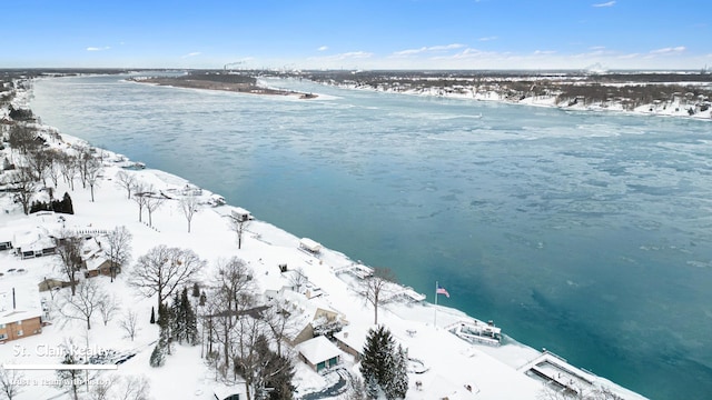 snowy aerial view featuring a water view