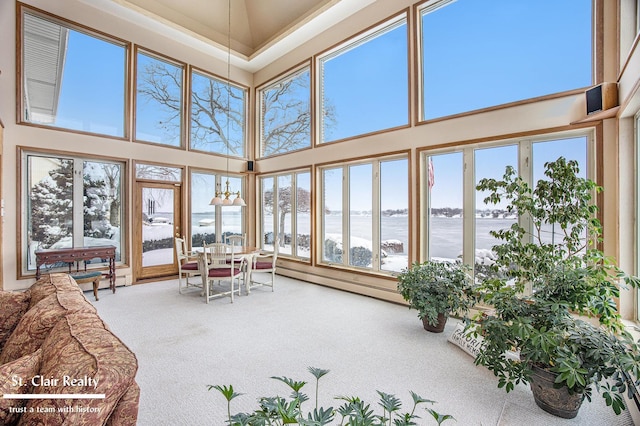 sunroom featuring a baseboard heating unit and a water view