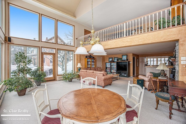 carpeted dining area with a towering ceiling