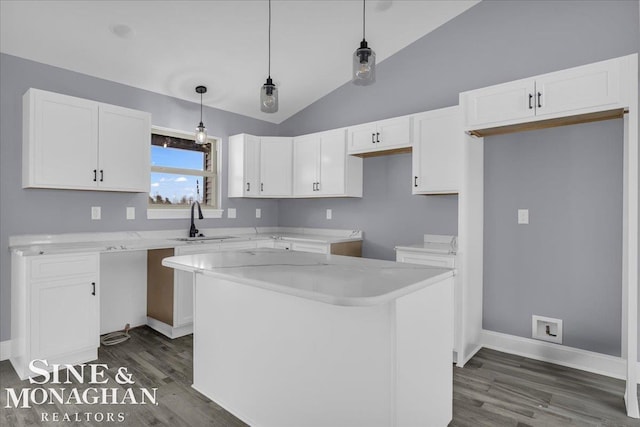 kitchen with a sink, white cabinetry, light countertops, a center island, and pendant lighting