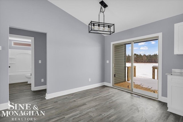 unfurnished dining area featuring dark wood-style floors, visible vents, vaulted ceiling, a chandelier, and baseboards