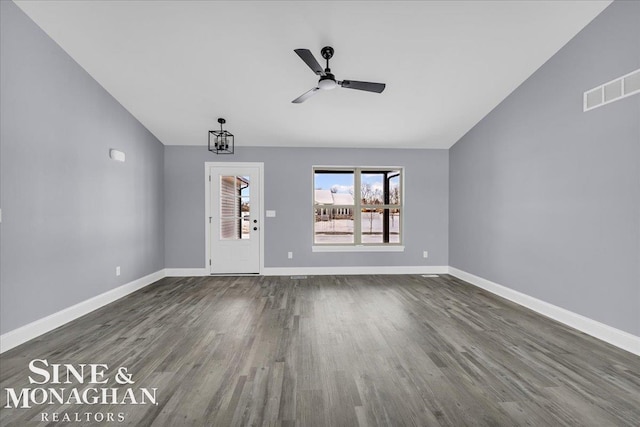 unfurnished living room featuring lofted ceiling, baseboards, visible vents, and dark wood finished floors