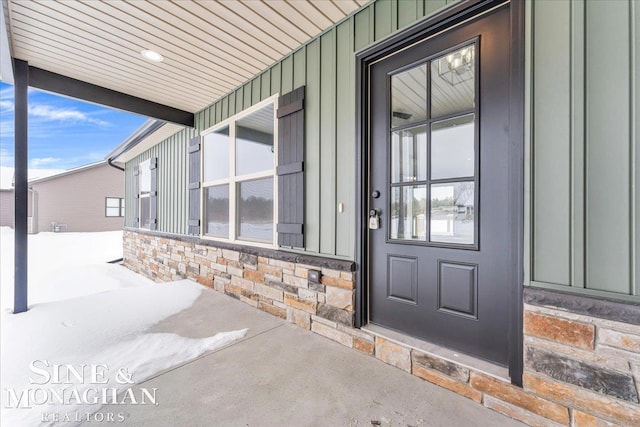 doorway to property featuring stone siding and board and batten siding