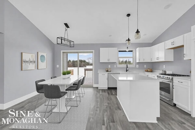 kitchen featuring white cabinetry, a kitchen island, appliances with stainless steel finishes, and light countertops