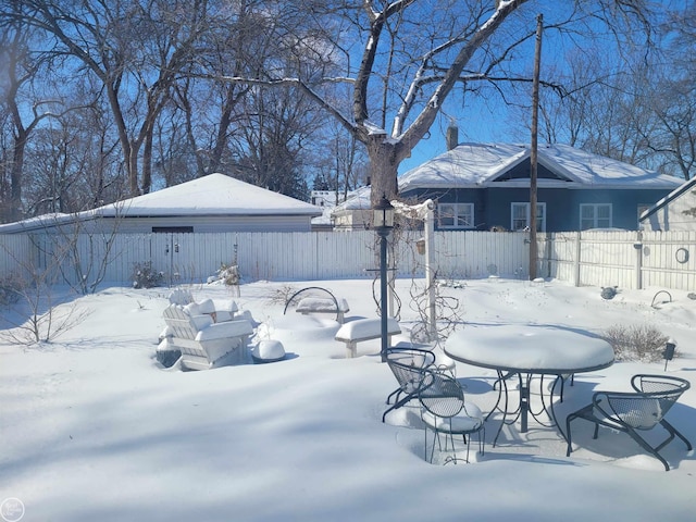 yard layered in snow featuring fence