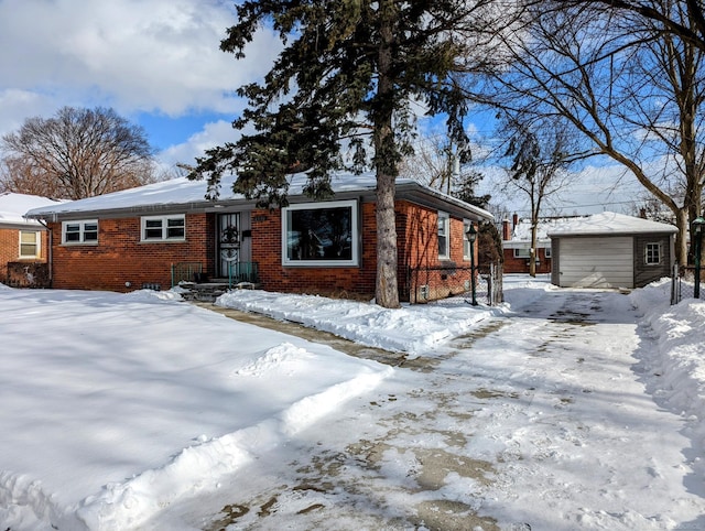 view of front of property featuring a garage, an outdoor structure, and brick siding