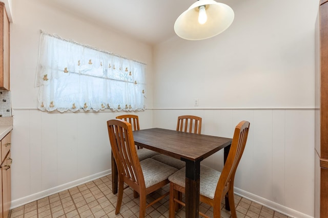 dining room with a wainscoted wall