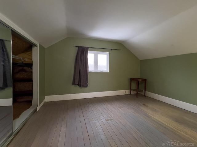 bonus room featuring lofted ceiling, baseboards, and wood finished floors