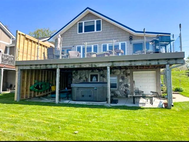 back of house with a yard, a hot tub, stone siding, and a patio