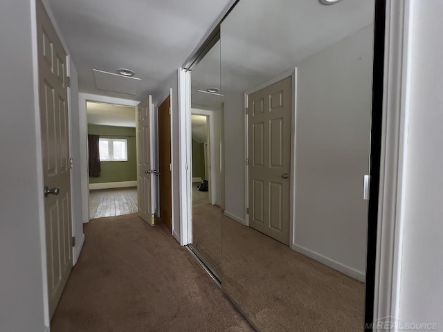 corridor featuring baseboards and light colored carpet