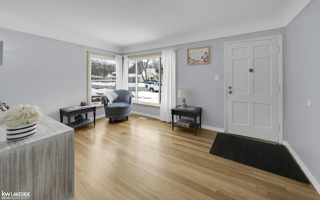 living area featuring light wood-style floors and baseboards