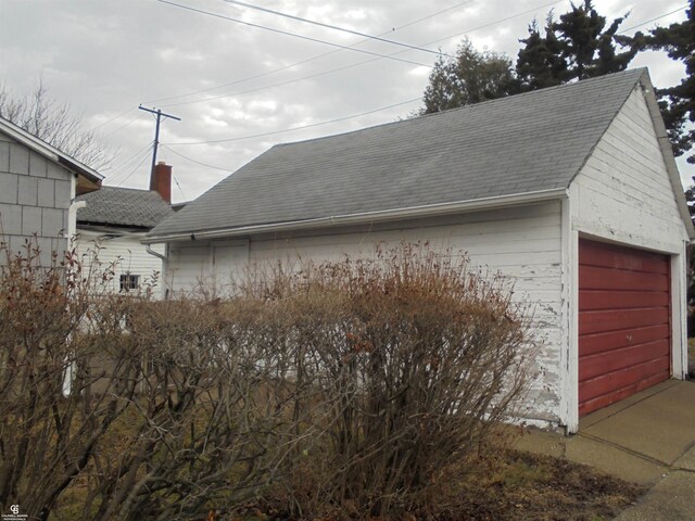 3606 Cadieux Rd, Detroit, MI 48224 - exterior space with a garage, roof with shingles, a chimney, and an outbuilding