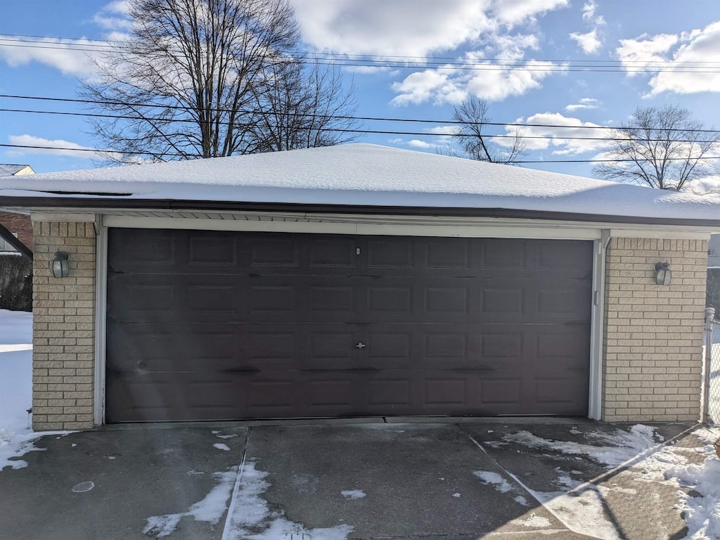 snow covered garage featuring a detached garage