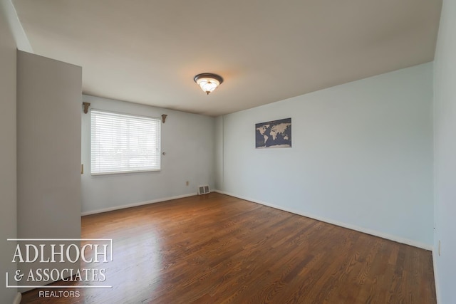 unfurnished room with wood finished floors and visible vents