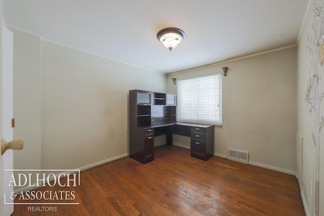 unfurnished office featuring baseboards, crown molding, visible vents, and dark wood-type flooring